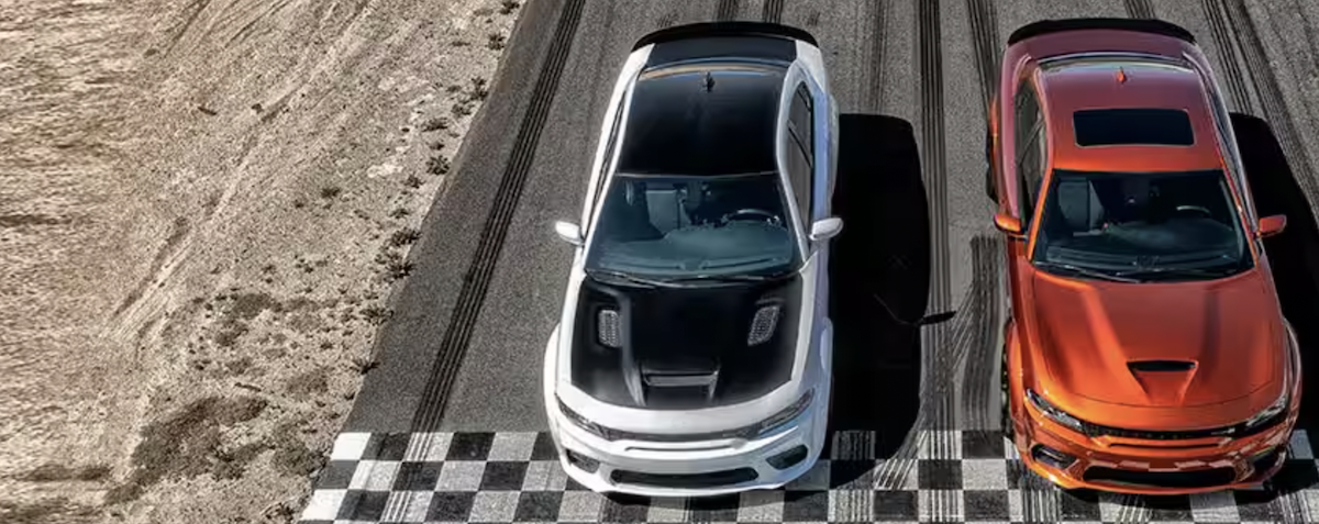 two Dodge muscle cars lineup up to race